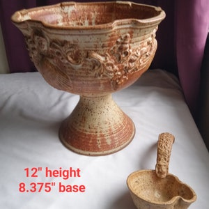 May include: A brown and white ceramic punch bowl with a 12" height and 8.375" base. The bowl has a decorative design and comes with a matching ladle.