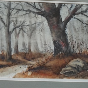 May include: Watercolor painting of a misty forest scene. Bare trees with dark trunks and branches dominate the foreground. A path leads through the woods, with a large rock and brown foliage in the lower right corner. Signed "John Grotke".
