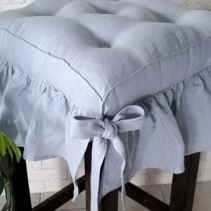 Può includere: Cuscino per sedia in lino blu chiaro con bordo a balze e fiocco. Il cuscino è riempito con un'imbottitura morbida e confortevole.