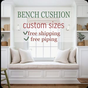 Op de afbeelding: Een lang, rechthoekig, gebroken wit bankkussen met bies, geplaatst op een ingebouwde vensterbank met vier vierkante sierkussens. De tekst op de afbeelding luidt: BENCH CUSHION, custom sizes, free shipping, free piping.