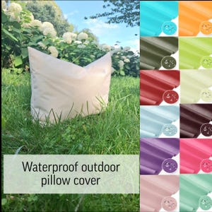 Könnte beinhalten: Ein beigefarbener, wasserdichter Outdoor-Kissenbezug liegt auf grünem Gras, mit weißen Blumen und blauem Himmel im Hintergrund. Eine Farbkarte zeigt wasserdichte Stoffmuster in verschiedenen Farben.