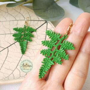 May include: Green crocheted fern earrings with gold hoops. Handmade jewellery by Artiwi.