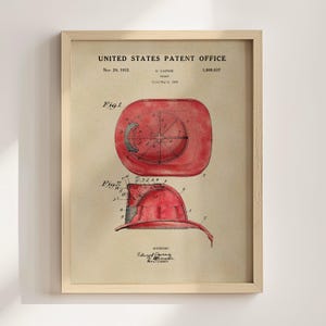 The image is a framed patent drawing depicting a red fire helmet with a circular design on the side.