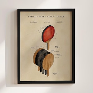 May include: Framed print of a ping pong paddle patent illustration. The print shows detailed diagrams of the paddle's construction, including layers of wood, graphite, and foam. The patent date is April 13, 1982.