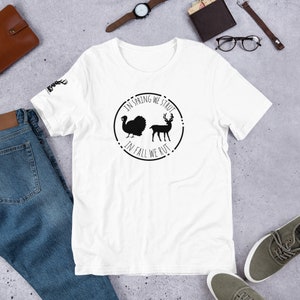Könnte beinhalten: Weißes T-Shirt mit einem schwarzen Kreis-Motiv, auf dem "In Spring We Strut, In Fall We Rut" steht. Das Motiv zeigt außerdem einen Truthahn und einen Hirsch.