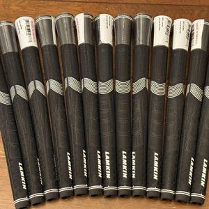 May include: A set of 12 black and white golf grips with the word "LAMKIN" printed on each grip.