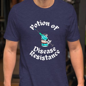 May include: Navy blue short-sleeve t-shirt with a graphic that reads "Potion of Disease Resistance." The graphic features a syringe and a vial with a blue liquid. The text and graphic are in white.