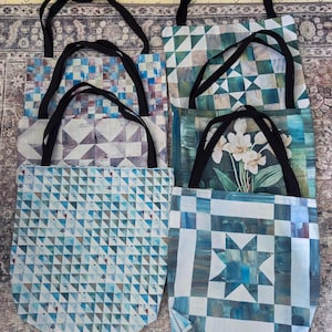 Peut inclure: Plusieurs sacs fourre-tout avec divers motifs géométriques et floraux. Les sacs ont des poignées noires et sont principalement bleus, blancs et verts. Les motifs comprennent des triangles, des carrés, une étoile et une impression florale.