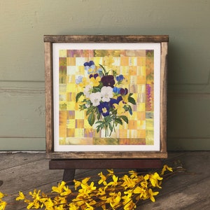 May include: A framed painting of a bouquet of purple, white, and yellow pansies on a yellow and orange checkered background.