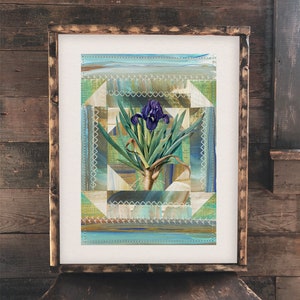Può includere: Un'opera d'arte incorniciata con un fiore di iris viola con foglie verdi su uno sfondo di tessuto patchwork blu, verde e marrone.