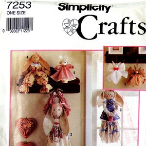 May include: Simplicity Crafts pattern featuring various handmade Easter bunny and angel ornaments. The image shows several fabric dolls with long ears, dresses, and decorative elements. The pattern includes instructions for creating these festive decorations.