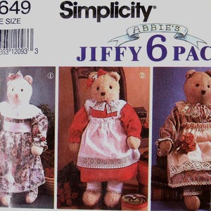 May include: Simplicity pattern 7649, featuring three teddy bears in different outfits. The bears are dressed in floral dresses, aprons, and bonnets. The pattern includes the text "Abbie's Jiffy 6 Pack" and a barcode.