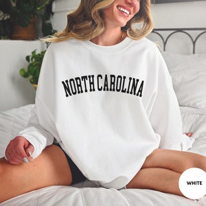 May include: White sweatshirt with the text "NORTH CAROLINA" in black lettering.