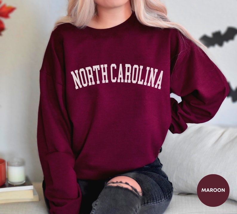 May include: Maroon sweatshirt with the text "NORTH CAROLINA" in white lettering.