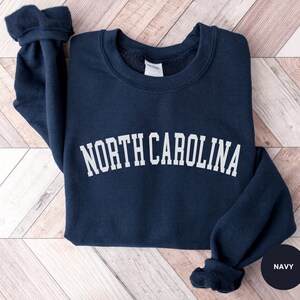 May include: A navy blue sweatshirt with the text "NORTH CAROLINA" in white lettering.