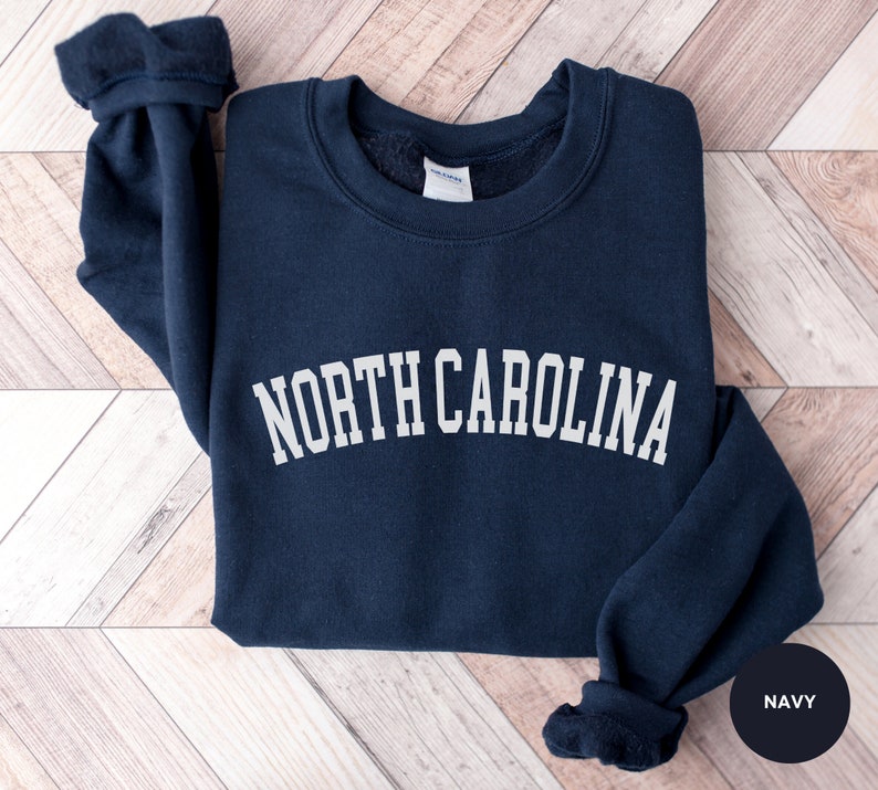 May include: A navy blue sweatshirt with the text "NORTH CAROLINA" in white lettering.