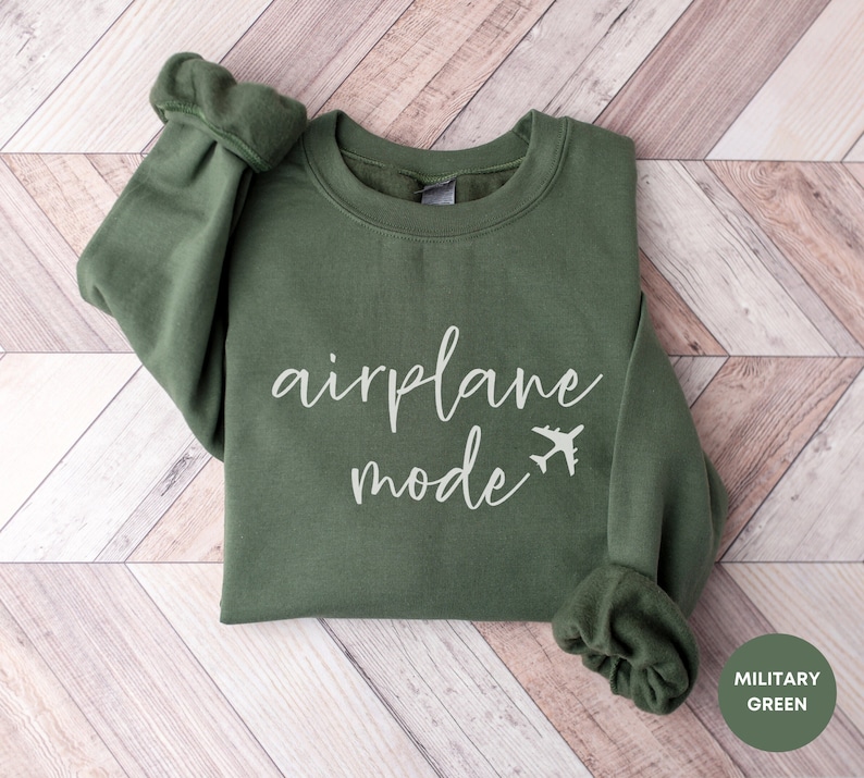 May include: A green sweatshirt with the text "airplane mode" and a small airplane icon in white.