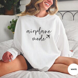 May include: White sweatshirt with the text "airplane mode" and a small airplane icon in black.