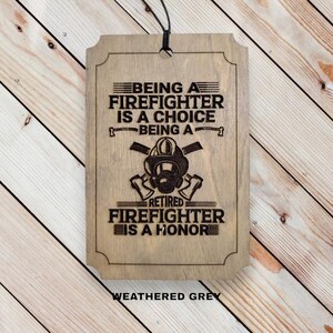 May include: A weathered gray wooden sign with the text "Being a Firefighter is a Choice Being a Retired Firefighter is a Honor". The sign features a firefighter helmet with crossed axes.