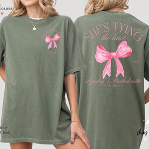 a woman wearing a green shirt with a pink bow on it