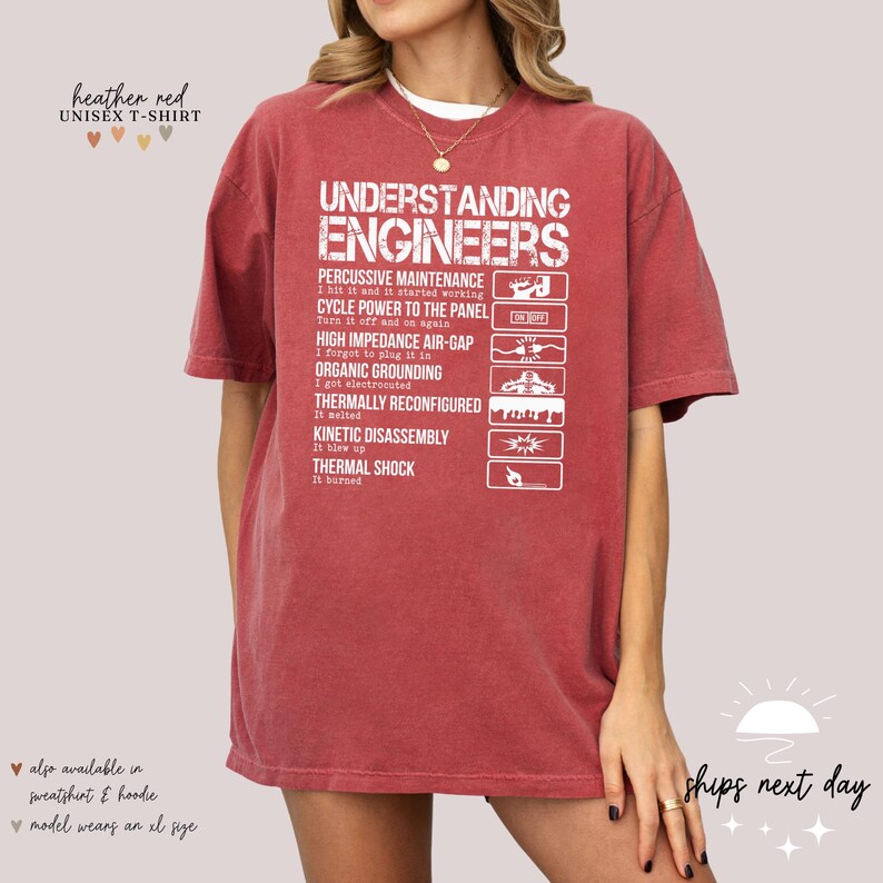 May include: Heather red unisex t-shirt with a white graphic that says "Understanding Engineers" and lists a humorous definition of the term. The graphic includes icons and text such as "Percussive Maintenance", "Cycle Power to the Panel", "High Impedance Air-Gap", "Organic Grounding", "Thermally Reconfigured", "Kinetic Disassembly", "Thermal Shock".