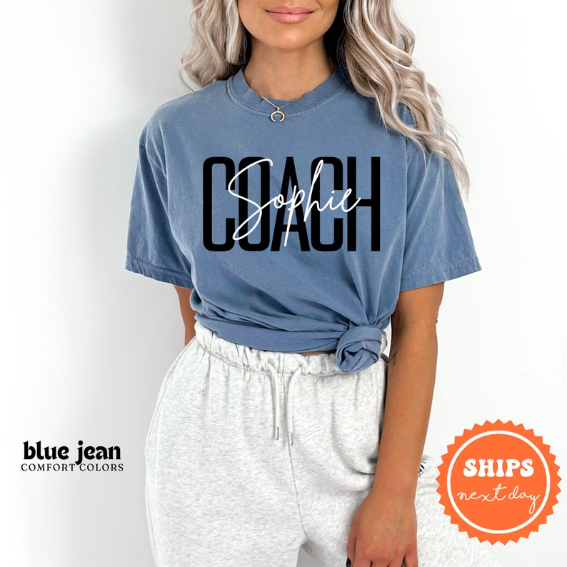 a woman wearing a blue shirt with the word coach on it