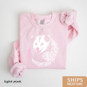 a pink shirt with a white hedge on it