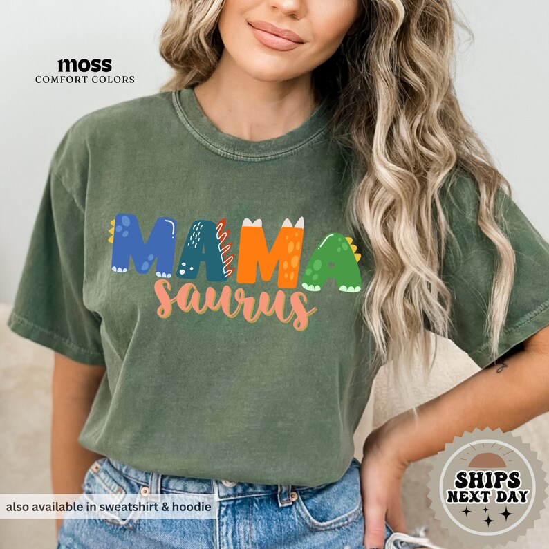 a woman wearing a green shirt that says mamasauruss