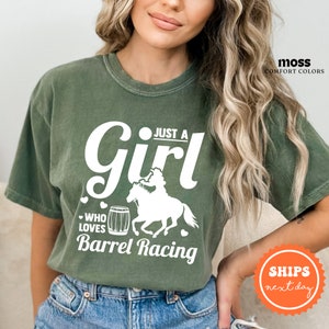 a woman wearing a t - shirt that says just a girl who loves barrel racing