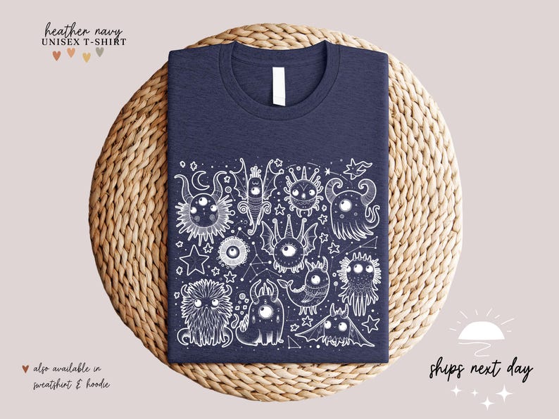 May include: Heather navy unisex t-shirt with a white graphic print of a constellation of cute monsters. The graphic features a variety of creatures with large eyes, stars, and crescent moons.