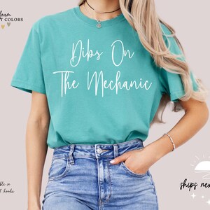 May include: A turquoise blue t-shirt with the text "Dips On The Mechanic" in white lettering.