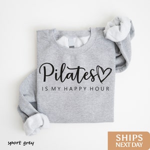 a sweatshirt with the words pilates is my happy hour printed on it