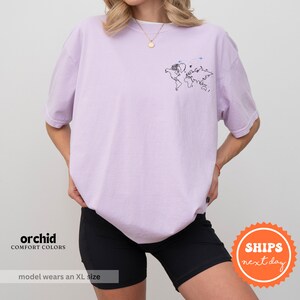 a woman wearing a purple shirt and black shorts