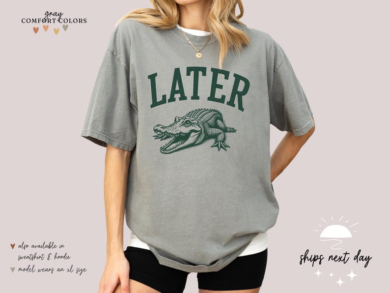 a woman wearing a gray shirt with a green alligator on it