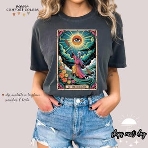 a woman wearing a t - shirt with an image of a woman holding a sun