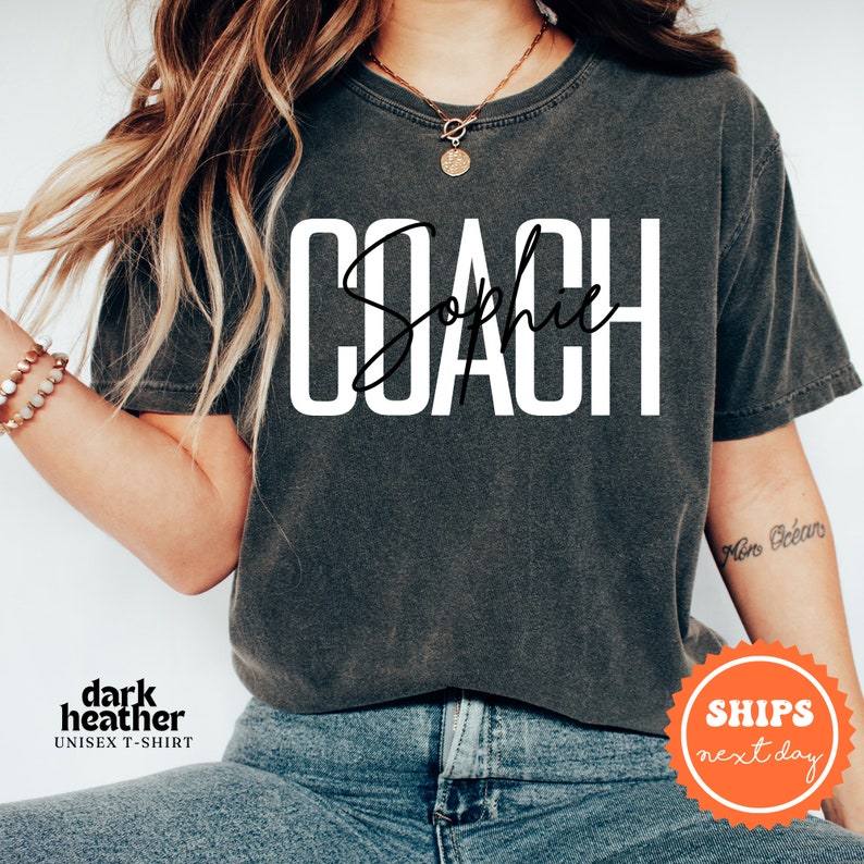 a woman wearing a black shirt with the word coach on it