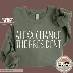 May include: A military green sweatshirt with the text "Alexa Change The President" printed in white.