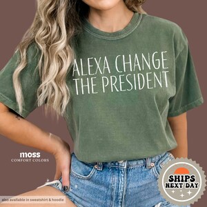 May include: A green t-shirt with the text "Alexa Change The President" printed in white.