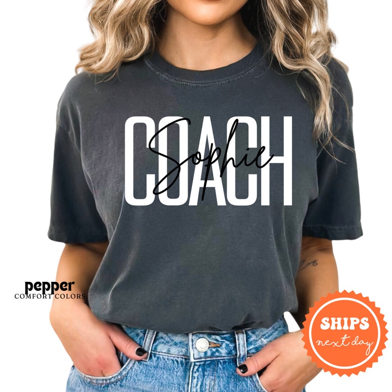 a woman wearing a black shirt with the word coach on it