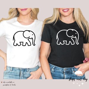 May include: Two t-shirts with a simple line drawing of an elephant. One t-shirt is white with a black elephant, and the other is black with a white elephant.