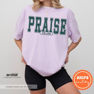 a woman wearing a purple shirt that says praise the lord