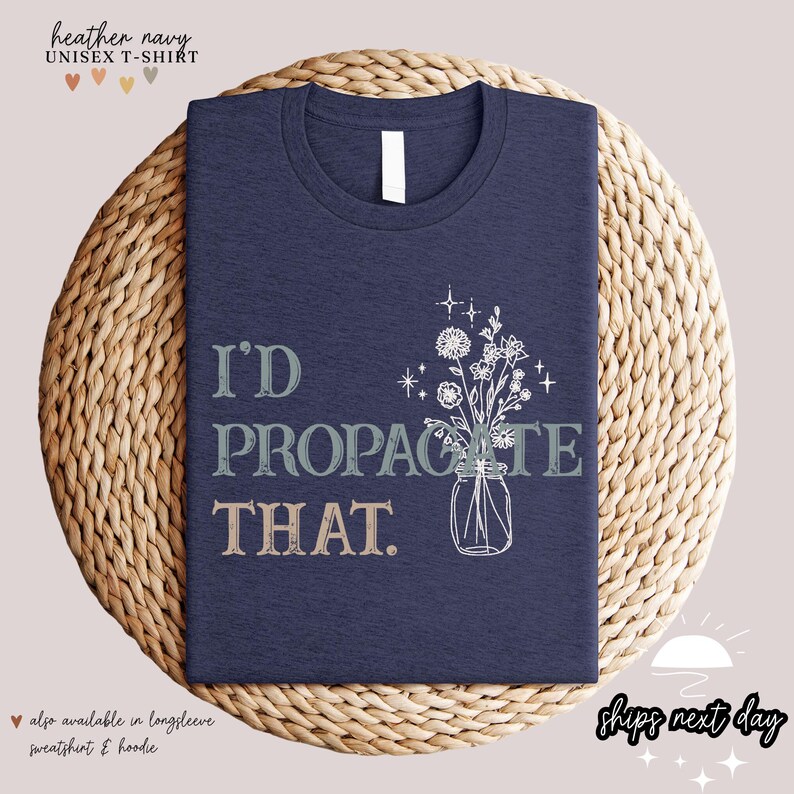 Puede incluir: Camiseta unisex azul marino jaspeado con el texto "I'D PROPAGATE THAT" y una ilustraci&oacute;n floral en un tarro de cristal. La camiseta se muestra sobre una esterilla tejida. Tambi&eacute;n disponible en sudadera y sudadera con capucha de manga larga.