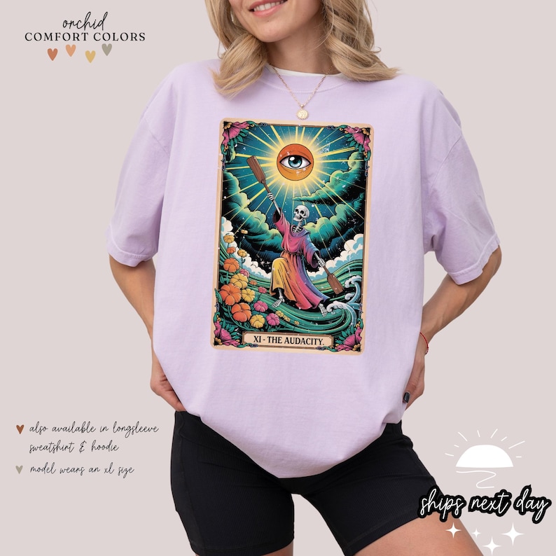a woman wearing a purple t - shirt with a picture of a woman holding a