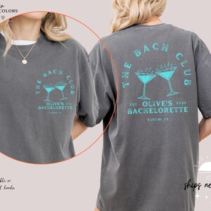 a woman wearing a gray t - shirt with a blue martini on it