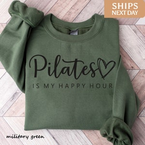 a green sweatshirt that says pilates is my happy hour