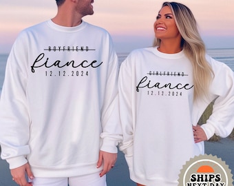 May include: White sweatshirts with black text that reads "Boyfriend fiance 12.12.2024" and "Girlfriend fiance 12.12.2024".