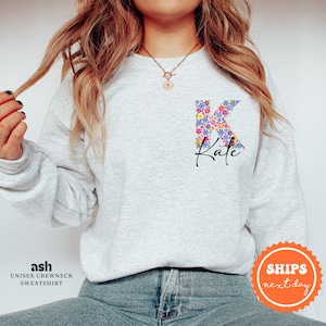 May include: A gray sweatshirt with a floral letter K and the name "Kate" printed on the front.