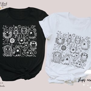 May include: Two t-shirts with a black and white design of various cartoon monsters and stars. The design is printed on a black t-shirt and a white t-shirt.