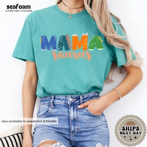 a woman wearing a green shirt with the word mama on it