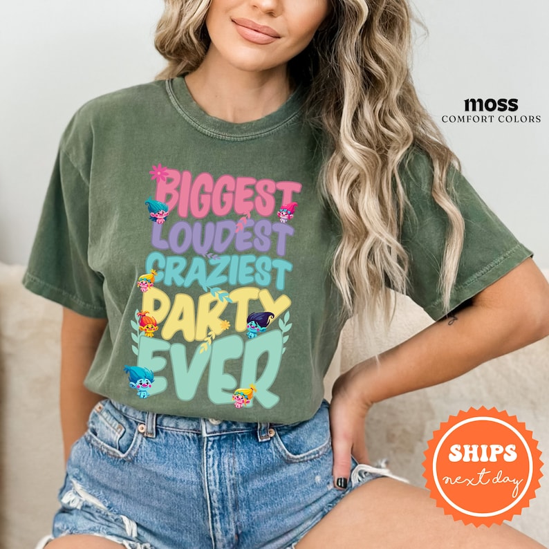 a woman wearing a green t - shirt that says biggest loudest crazy party ever